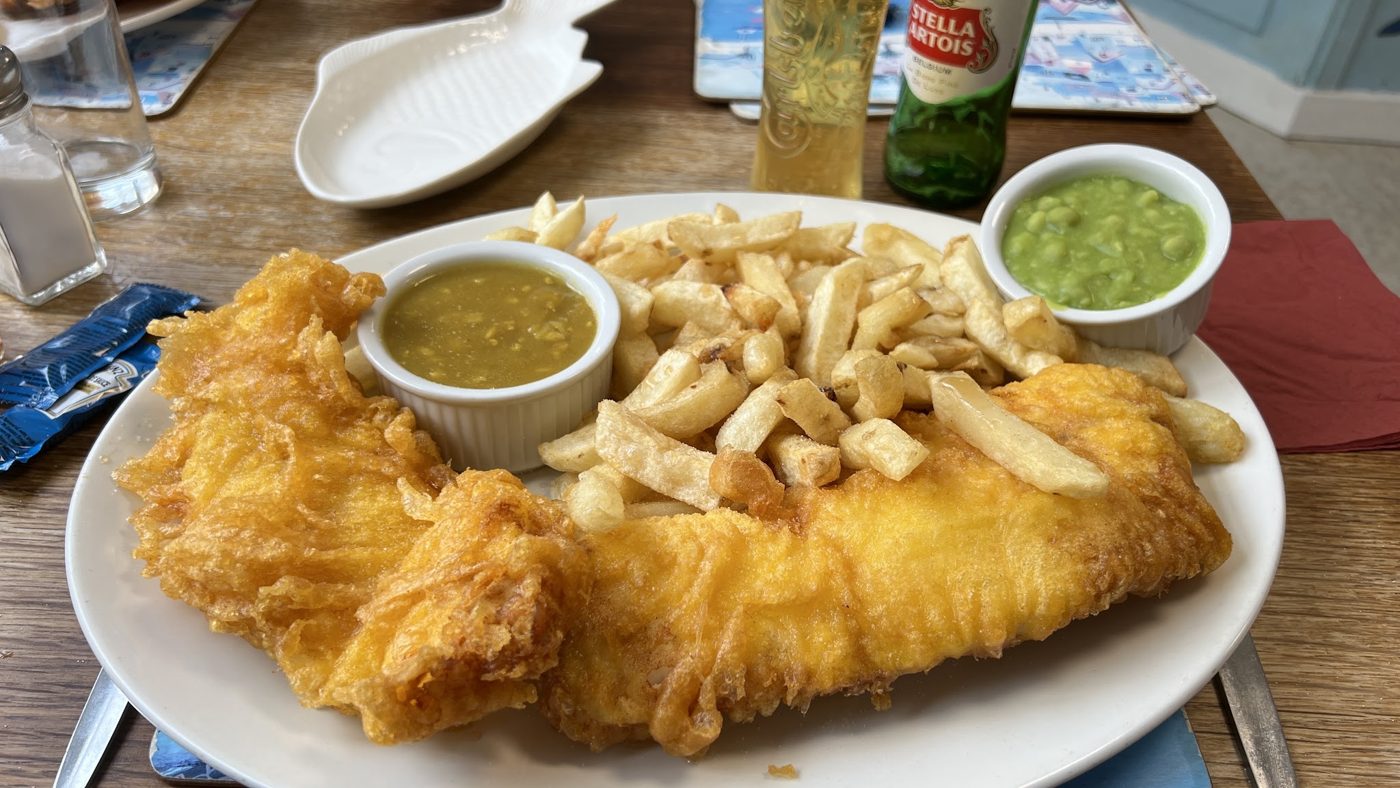 Battered fish and chips with mushy peas and curry sauce