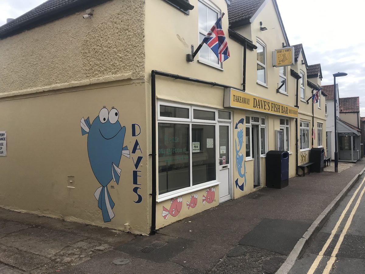 The cream corner building with a blue fish painted on the wall